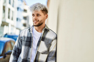 Young hispanic man smiling happy standing at the city.