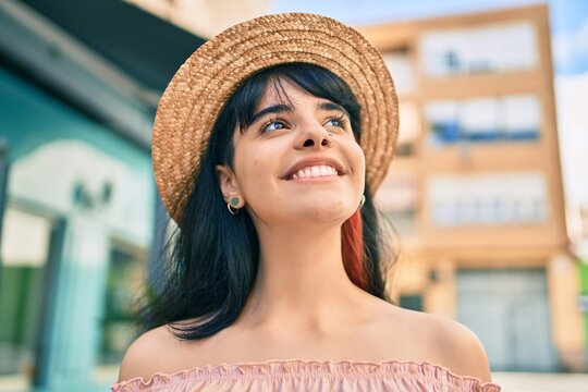 Young hispanic tourist girl wearing summer style walking at the city.