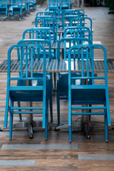 Tables and blue chairs. Closed for business