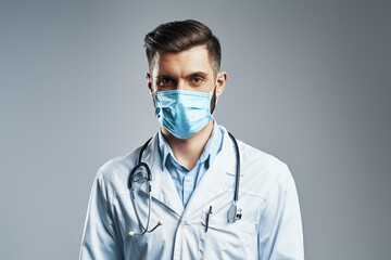 Confident young man in white lab coat 