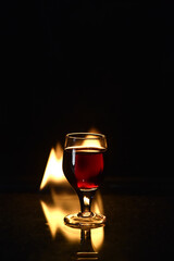 Fototapeta na wymiar red drink with fire behind and reflection on black background