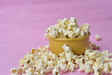 Warm popcorn viewed from above on pink background. Top view. Enterteinment concept