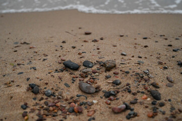 Small stones by the sea with an approaching wave