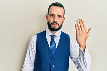 Young man with beard wearing engagement ring thinking attitude and sober expression looking self confident