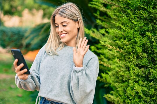 Young blonde girl smiling happy doing video call using smartphone at the park