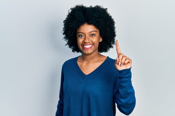 Young african american woman wearing casual clothes smiling with an idea or question pointing finger up with happy face, number one
