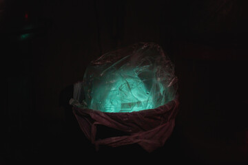 Plastic bags in trash cans that glow in the dark because of microbes and bacteria from squids.