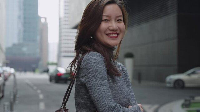 slow motion lovley asian lady looking at camera smile in the urban city street at Chengdu China Chinese businesswoman portrait