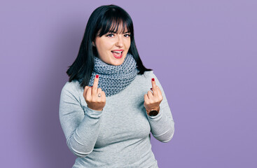 Young hispanic plus size woman wearing winter scarf showing middle finger doing fuck you bad...