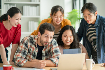 Business people in casual clothes looking something at laptop together with exciting face expression. Win a new project concept, happy from a good thing in workplace.