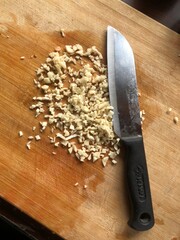 Sliced garlic cloves on wooden chopping Board