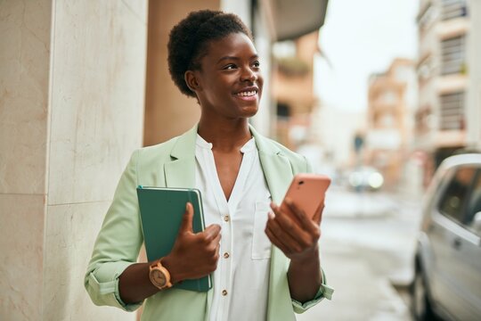 Young african american businesswoman smiling happy using smartphone at the city.