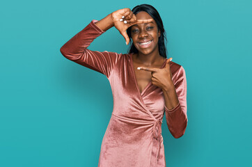Fototapeta premium Young african american woman wearing sexy party dress smiling making frame with hands and fingers with happy face. creativity and photography concept.