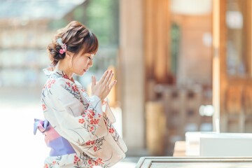 お参りする浴衣姿の女性
