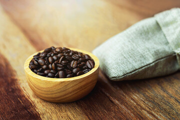 Coffee beans in a wooden cup on the table surface