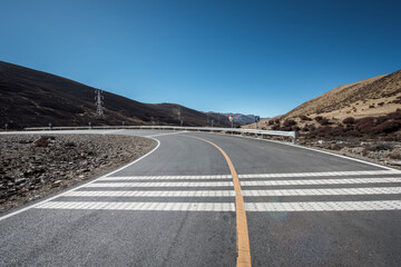 An open road under a snowy mountain