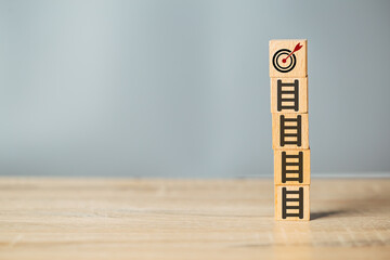 Bullseye is a target of business.target board on up arrows which print screen on wooden cube block, business achievement objective target concept.