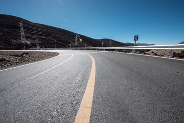 Fototapeta premium An open road under a snowy mountain