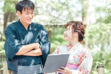 タブレットを使う浴衣姿の男女
