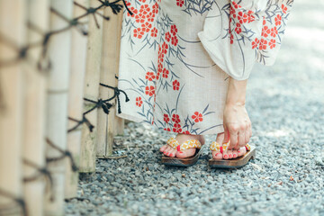 下駄を直す浴衣姿の女性
