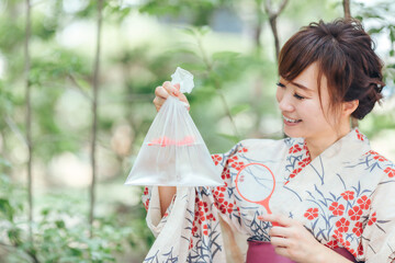 金魚すくいでおもちゃを釣る女性
