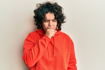 Fototapeta na wymiar Young hispanic woman with curly hair wearing casual sweatshirt feeling unwell and coughing as symptom for cold or bronchitis. health care concept.
