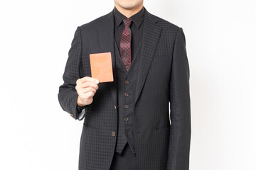 白背景の前に立って、レッドカードを示す男性ビジネスマン