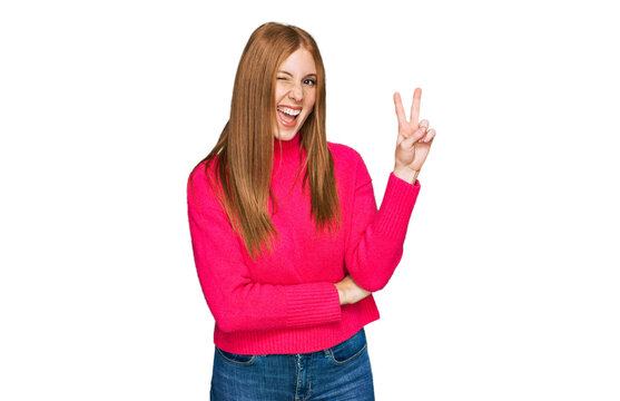 Young irish woman wearing casual clothes smiling with happy face winking at the camera doing victory sign. number two.