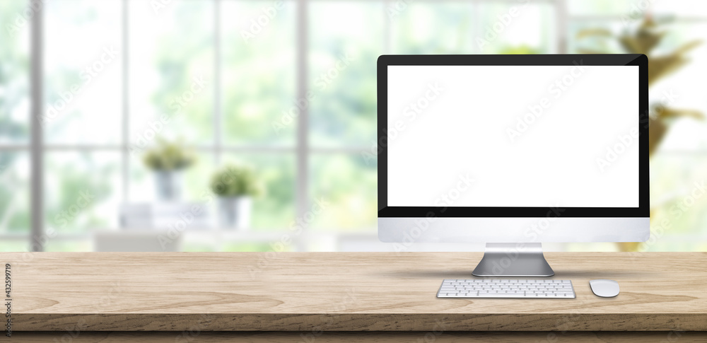 Poster desktop computer blank screen mockup on wooden table with blur window garden at home.banner space fo