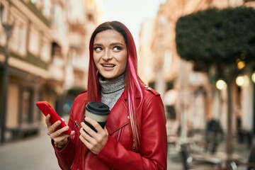Young caucasian girl smiling happy using smartphone and drinking coffee at the city.