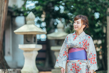 神社を歩く浴衣姿の女性
