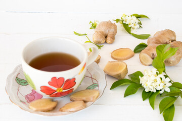 hot ginger water herbal healthy drinks health care for cough sore with flowers jasmine arrangement flat lay style on background wooden white