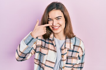 Young caucasian girl wearing casual clothes pointing with hand finger to face and nose, smiling cheerful. beauty concept