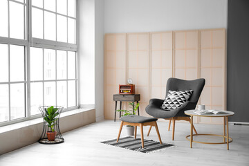 Interior of modern room with comfortable armchair and table