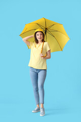 Stylish young woman with umbrella on color background