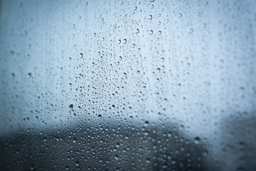 Raindrops on a window, rainy weather, cloudy day. Selective focus, blurred edges.