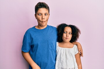 Obraz premium Young hispanic family of brother and sister wearing casual clothes together making fish face with lips, crazy and comical gesture. funny expression.