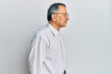 Middle age indian man wearing casual clothes and glasses looking to side, relax profile pose with natural face with confident smile.