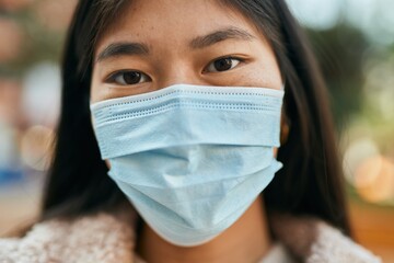 Young asian woman wearing medical mask standing at the city.