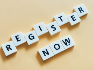 Obraz premium Text register now made from square letter tiles with black font on orange background.