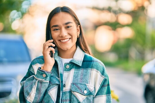 Young latin girl smiling happy talking on the smartphone at the city.