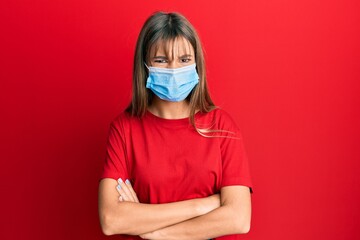 Teenager caucasian girl wearing medical mask skeptic and nervous, disapproving expression on face with crossed arms. negative person.