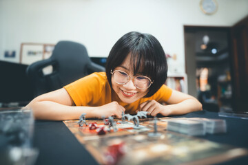 Young adult asian woman playing board game on top table at home.