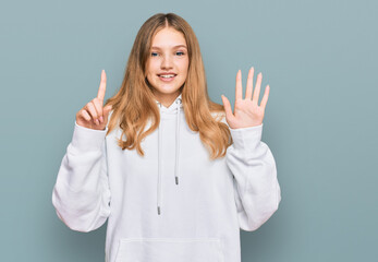 Beautiful young caucasian girl wearing casual sweatshirt showing and pointing up with fingers number six while smiling confident and happy.