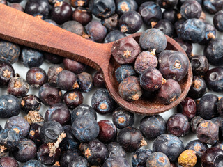 spoon on pile of dried juniper berries closeup