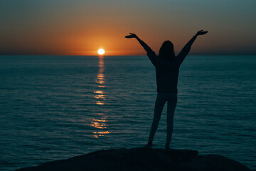 Fototapeta premium female silhouette gesturing with hands sunset sea model