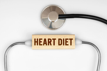 On the table is a stethoscope and a wooden plate with the inscription - HEART DIET