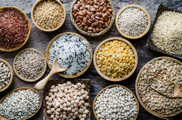 Variety kind of dry organic cereal and grain seeds in wooden and ceramic bowl in dark tone, for healthy or clean food ingredient or agricultural product concept