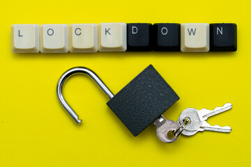 an open padlock with keys on a yellow background at the top the inscription lockdown is laid out from the keys of a computer keyboard the concept of data protection prohibitions