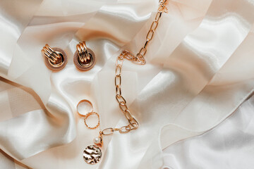 Women's jewelry, gold chain, trendy jewelry on a silk background.